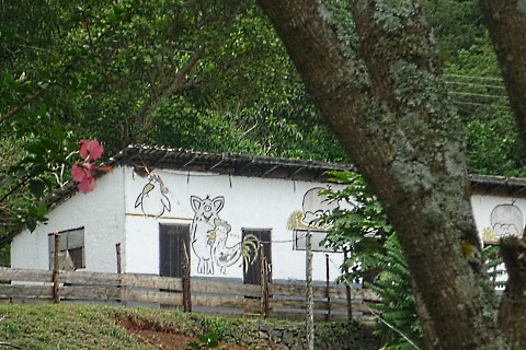 ein weißes Haus, auf das drei Schweine, ein Huhn und ein Hahn gezeichnet wurden, im Stil von "Die drei Freunde" von Helme Heine