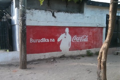 das Foto zeigt eine Wand, die mit Werbung von Coca-Cola bemalt ist