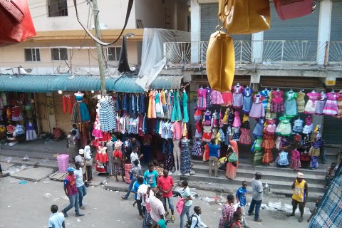 Bunte Marktstände mit vielen Stoffen und Kleidung im Viertel Kariakoo in Daressalam.